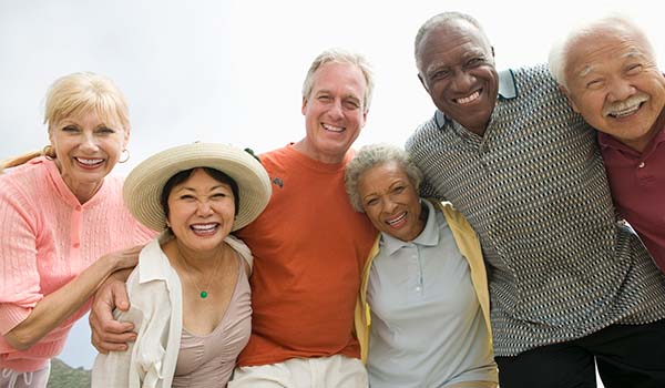 Six older people of different sexes and ethnicities smiling together